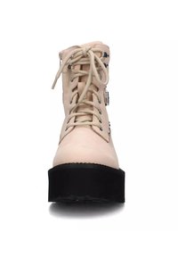 Stivaletti alla caviglia in pelle rosa chiaro con suola platform nera, dotati di lacci frontali e accenti in metallo argentato. Trama liscia e punta rotonda.