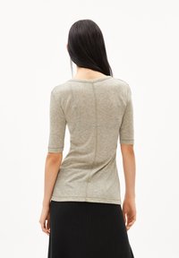Světlá šedá přiléhavá tričko s krátkými rukávy, kulatým výstřihem a švy na zadní straně. Texturovaná tkanina s jemným vzhledem.