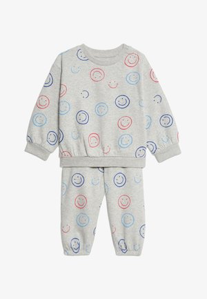 Completo felpa grigia e pantaloni, con motivi a faccina sorridente blu e rossi, realizzato in tessuto morbido con polsini ed elastico in vita.