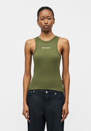 Γυναίκα που φοράει χακί αμάνικη ριμπ μπλούζα με το κείμενο "Palm Angels", συνδυασμένη με μαύρο τζιν ψηλόμεσο παντελόνι, στέκεται μπροστά σε απλό φόντο.