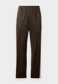 Bruine sportbroek met een elastische tailleband, zijstrepen in een lichtere tint en een zak met een klein logoaccent. Gladde structuur.