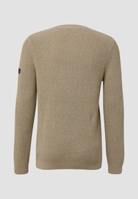 Beige gestrickter Pullover mit gerippter Textur, langen Ärmeln und rundem Halsausschnitt. Enthält ein kleines schwarzes Logo-Patch am linken Ärmel.