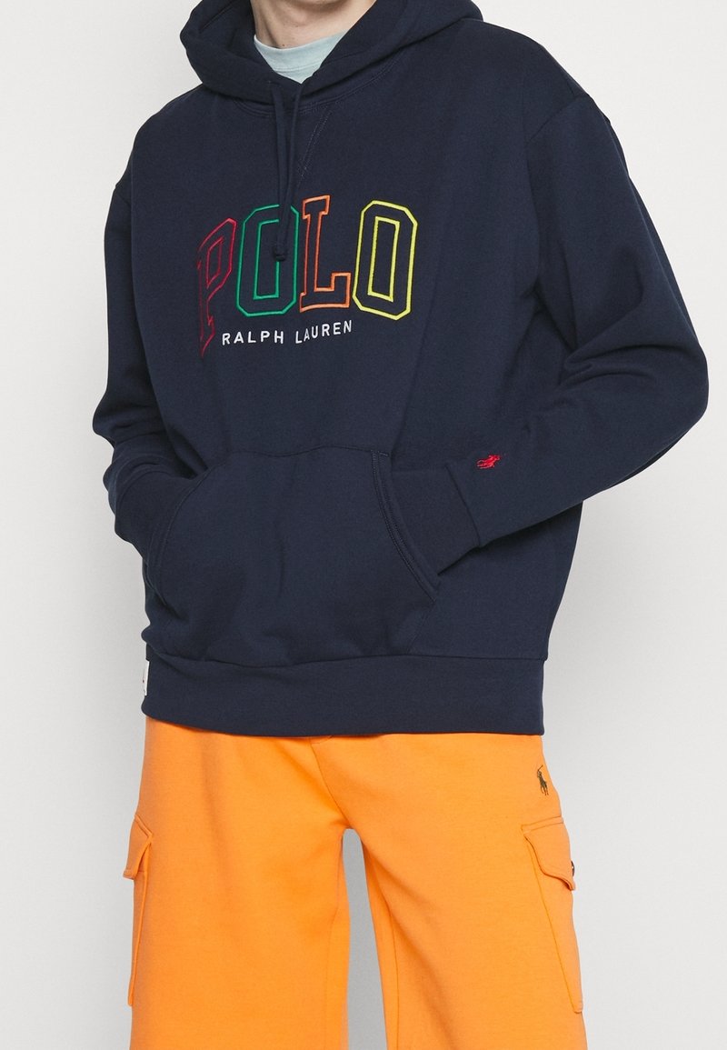 Marinblå bomullshoodie med en framficka, som har flerfärgad "POLO"-text och "RALPH LAUREN"-logotyp nedanför.