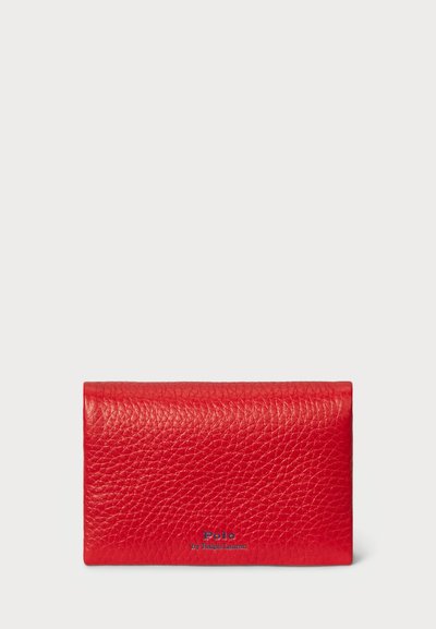 Sarkanais ādas maks ar teksturētu virsmu, ar salokāmu dizainu un „Polo by Ralph Lauren” logotipu zilā krāsā.