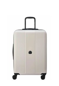 Valigia rigida di colore beige chiaro, con scanalature verticali, manico retrattile nero e quattro ruote nere. Inclusa una serratura circolare.