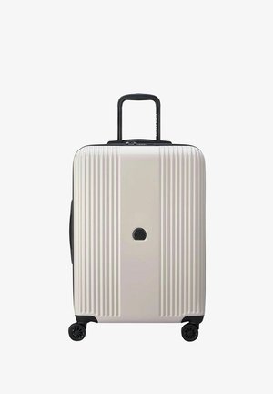 Valigia rigida di colore beige chiaro, con scanalature verticali, manico retrattile nero e quattro ruote nere. Inclusa una serratura circolare.