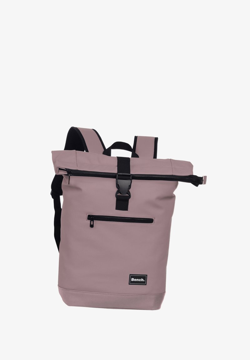 Sac à dos waterproof violet avec fermeture roulée, matériel noir, poche zippée à l'avant et bretelles rembourrées réglables. Logo sur le devant.