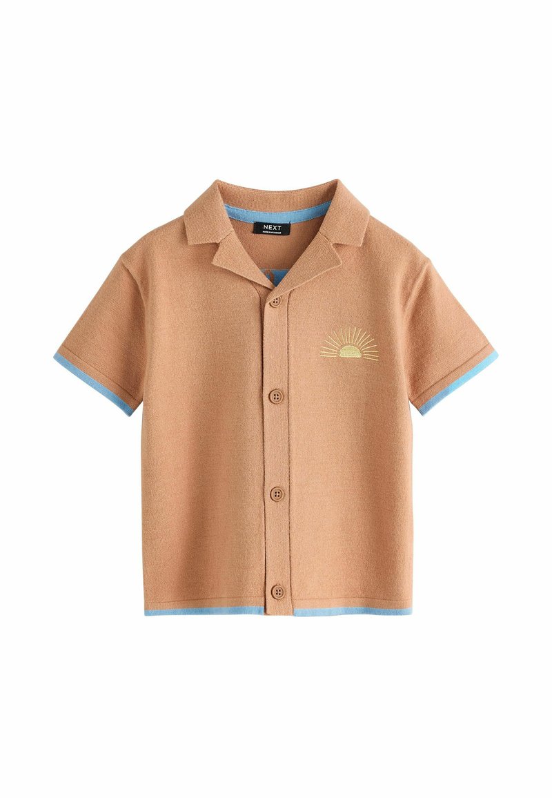 Camisa marrón de manga corta con botones, con ribete azul en las mangas y el dobladillo, y bordado de un sol amarillo en el pecho izquierdo.