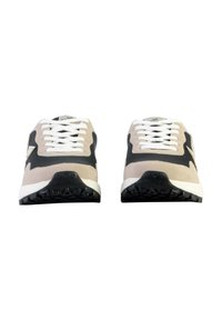 Sneaker in suede beige e nero con lacci bianchi, accentuazioni nere solide e suole in gomma nera texturizzata. Presenta un logo sulla linguetta.