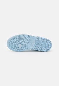 Semelle extérieure de chaussure Nike en caoutchouc bleu clair, présentant un motif de cercles concentriques et une texture en forme de grille pour une adhérence et une durabilité optimales.