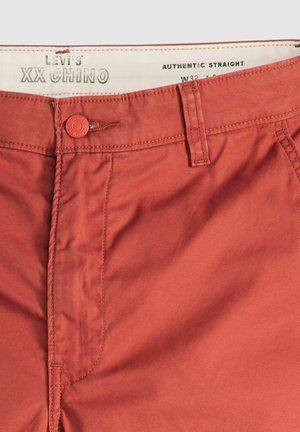 Rode chino-broeken met een gladde textuur, authentieke rechte pasvorm, taillemaat 32 inch, knoopsluiting en contrasterende stiksels op de zakken.