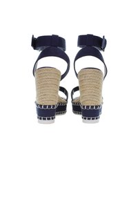 Námořnické modré sandály na podpatku s tkanou jutu, nastavitelným páskem kolem kotníku a bílými švy na podstavci a podpatku.