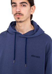 Sudadera azul marino de algodón, con capucha ajustable, logotipo bordado en el pecho y una tela suave y texturizada.