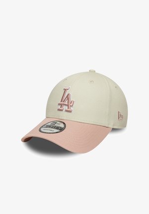 Gorra de béisbol ajustable en beige y rosa con el logo bordado "LA" en la parte frontal y la marca New Era en el lateral y la pegatina en la visera.