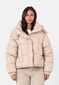 Helle beige Pufferjacke mit hohem Kragen, Druckknöpfen und gesteppten Details. Verfügt über elastische Bündchen und ein dezentes Logo-Patch.