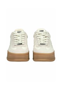 Kremowe skórzane sneakersy z zamszowymi akcentami, płaskimi sznurowadłami i grubą gumową podeszwą. Posiadają logo na języku i boku. Klasyczny design.