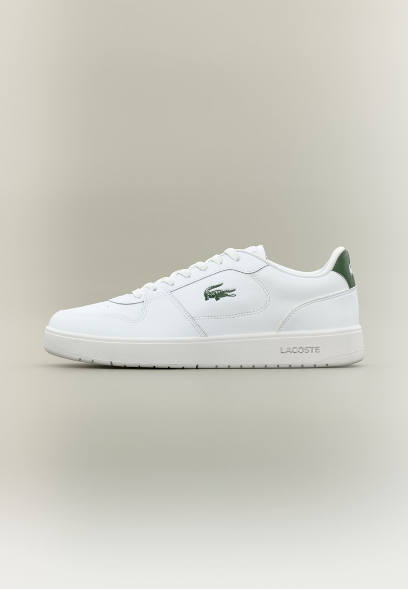 White leather sneaker with a smooth finish, green accents on the heel, and a green logo on the side. Features a flat sole and round toe.