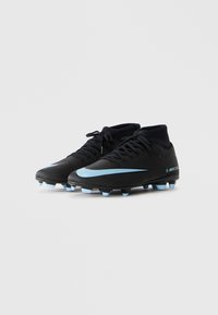 Mustat Nike Mercurial jalkapallokengät vaaleansinisen swoosh-logon ja nappuloiden kanssa, etuosan näkymä valkoista taustaa vasten.