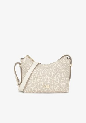 Bolso de hombro beige con un diseño curvado, que presenta un cierre de cremallera en tono dorado y una correa ajustable. Logo de la marca embellecido en la parte frontal.