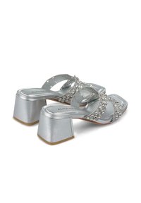Sandali con tacco quadrato argentati, con cinturini incrociati decorati con strass e un design con tacco spesso.
