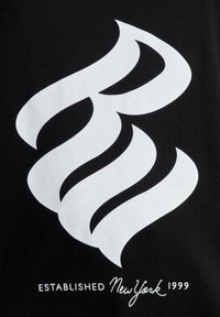 Čierne tričko s veľkým bielym vírivým logom. Text nižšie znie "ZALOŽENÉ New York 1999" v bielom serifovom písmene.