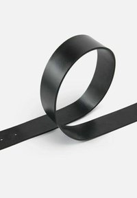 Cintura nera in pelle con una texture liscia e un design semplice e arrotondato. Presenta fori tagliati lungo un'estremità piatta per la regolazione della misura.