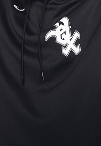 Sweat à capuche noir avec logo "Sox" stylisé en blanc sur la poitrine et cordons noirs à embouts métalliques.