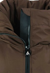 Veste isolante marron avec un col haut, une fermeture éclair noire et un tire-zip avec logo géométrique.