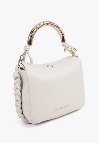 Vit läderhandväska med flätad sidodetailj, guldfärgad hårdvara och en strukturerad form. Har en gyllene logotyp på framsidan och ett runt handtag.