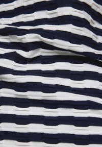 Marineblau- und weiß gestreifter Stoff mit einem strukturierten, geschichteten Design. Verfügt über abwechselnde horizontale Streifen, die ein erhabenes Muster erzeugen.