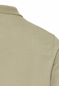 Polohemd in hellolivgrün mit strukturiertem Stoff. Verfügt über einen gestrickten Kragen und eine glatte Oberfläche am Oberteil.