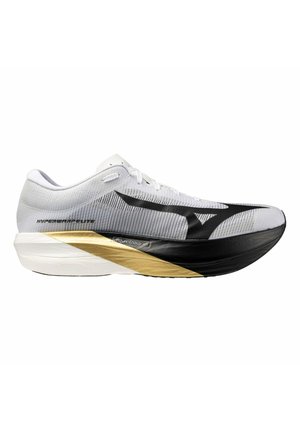 Zapatilla de correr blanca y negra con detalle dorado, parte superior de malla, suela gruesa y acolchada, y logo negro en el lateral.