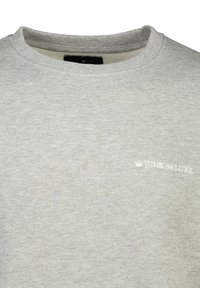 Felpa grigia realizzata in tessuto morbido, con scollo rotondo e un piccolo logo bianco "JUNK de LUXE" sulla parte sinistra del petto.