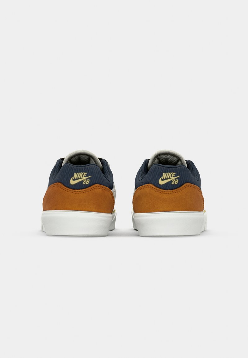 Nike SB Sneaker mit einem Obermaterial aus navyfarbenem Mesh, braunen Wildlederakzenten, grauem Futter und weißen Gummisohlen. Mit dem Nike-Logo auf der Ferse.