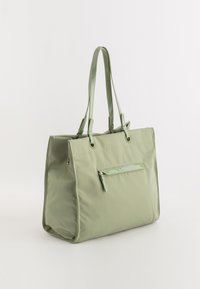 Grön nylon tote-väska med två blanka handtag, en framficka med dragkedja och sydda detaljer. Rektangulär form med en slät yta.