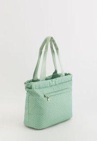 Mint green tote bag with a textured, dotted pattern. Dual fabric handles and a front zippered pocket. Rectangular shape and soft material.