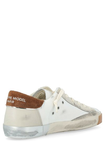 Sneaker bianchi a bassa top con tallone in suede beige, lacci beige, occhielli argentati e suola e dettagli laterali invecchiati.