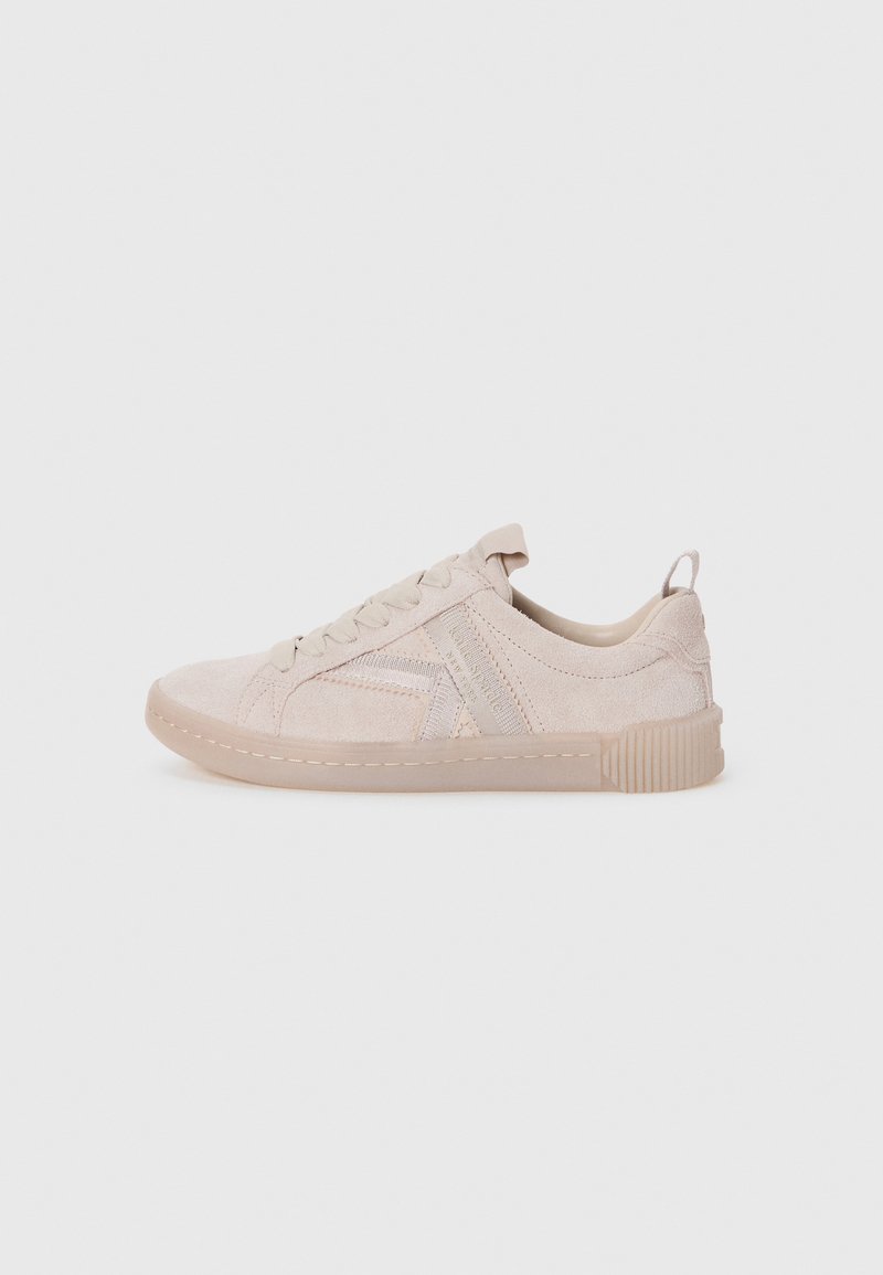 Light beige suede sneaker with round toe, lace-up front, rubber sole, and textured accents. Minimalist design with subtle stitching details.