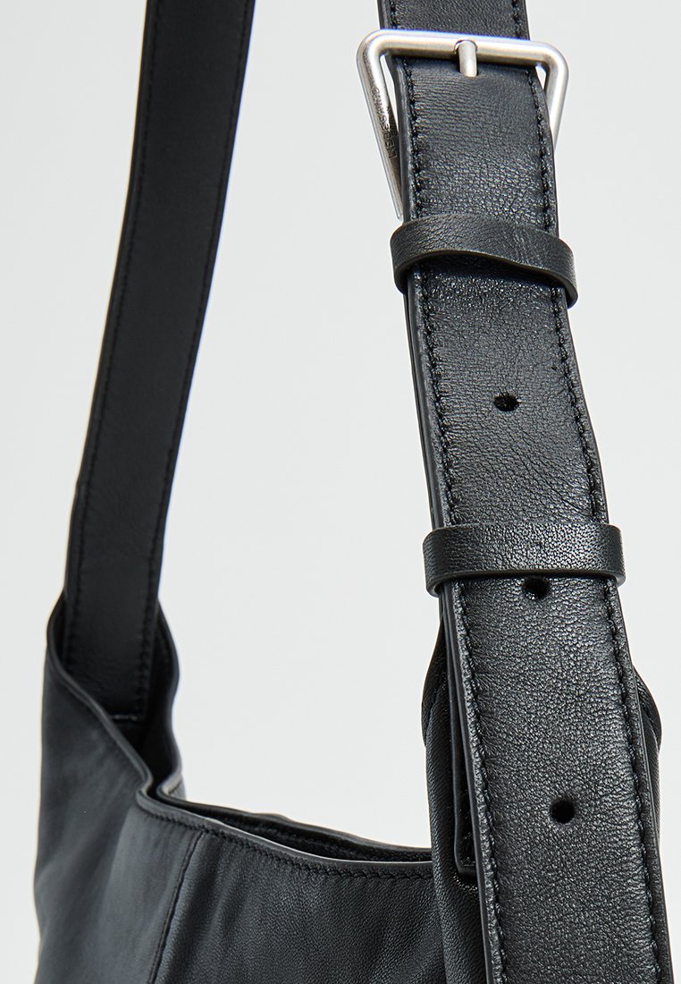 Schwarze Leder-Schultertasche mit glatter Textur, verstellbarem Riemen mit silberfarbener Schnalle und Löchern zur Längenanpassung.