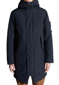 Mörkblå lång parka med huva, med dragkedja fram, sidofickor och rak passform. Slätt, vattentåligt tyg.