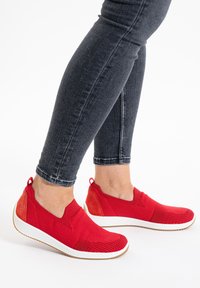 Rote Slipper aus strukturiertem Strickstoff mit Wildlederakzenten, featuring einer weißen Sohle und einem flexiblen Design für Komfort.