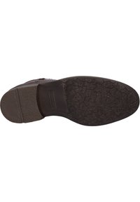 Semelle en caoutchouc noir avec un motif texturé. Tige en cuir lisse avec des coutures décoratives. Design élégant et moderne.