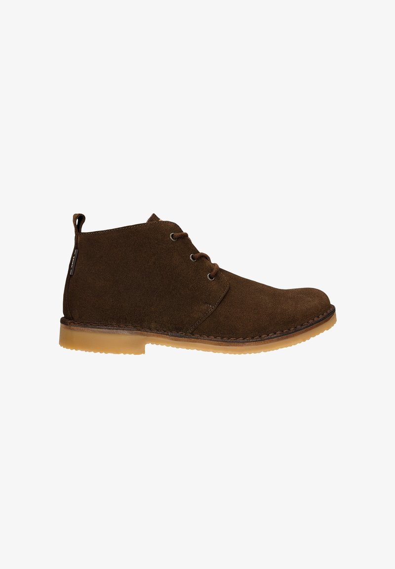 Bottines en daim marron avec un bout rond, deux œillets pour les lacets et une semelle en caoutchouc. Présentent un détail cousu le long du bord et une languette en boucle au talon.