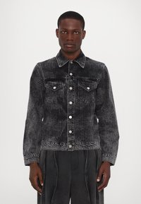 Jacheta din denim negru cu un model texturat, nasturi argintii, două buzunare pe piept și un guler clasic. Finisajul texturat sporește interesul vizual.