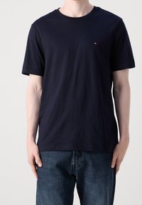 Camiseta de algodón azul marino de manga corta y cuello redondo, con un pequeño logo en el pecho y un corte relajado.