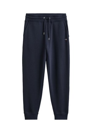 Marineblå joggebukser med elastisk midje, snor, sidelommer og ribbestrikkede mansjetter, med en liten brodert logo på høyre side.