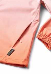 Veste dégradée en tissu doux, passant du rose à l'orange. Comprend des poignets élastiques, une poche zippée et une étiquette à motif en grille.