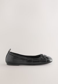 Ballerine plate en cuir noir texturé avec un petit noeud sur l'avant rond et une languette au talon.