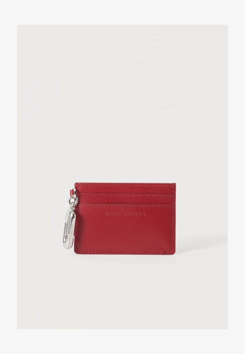 Porte-cartes en cuir rouge avec plusieurs emplacements et une pince métallique argentée fixée sur le côté gauche, sur un fond blanc uni.