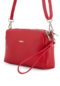 Red leather crossbody bag with a textured finish, silver hardware, and a zip closure. Includes a detachable strap for versatile carrying options.